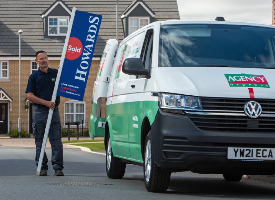 Agency signboard and van on site