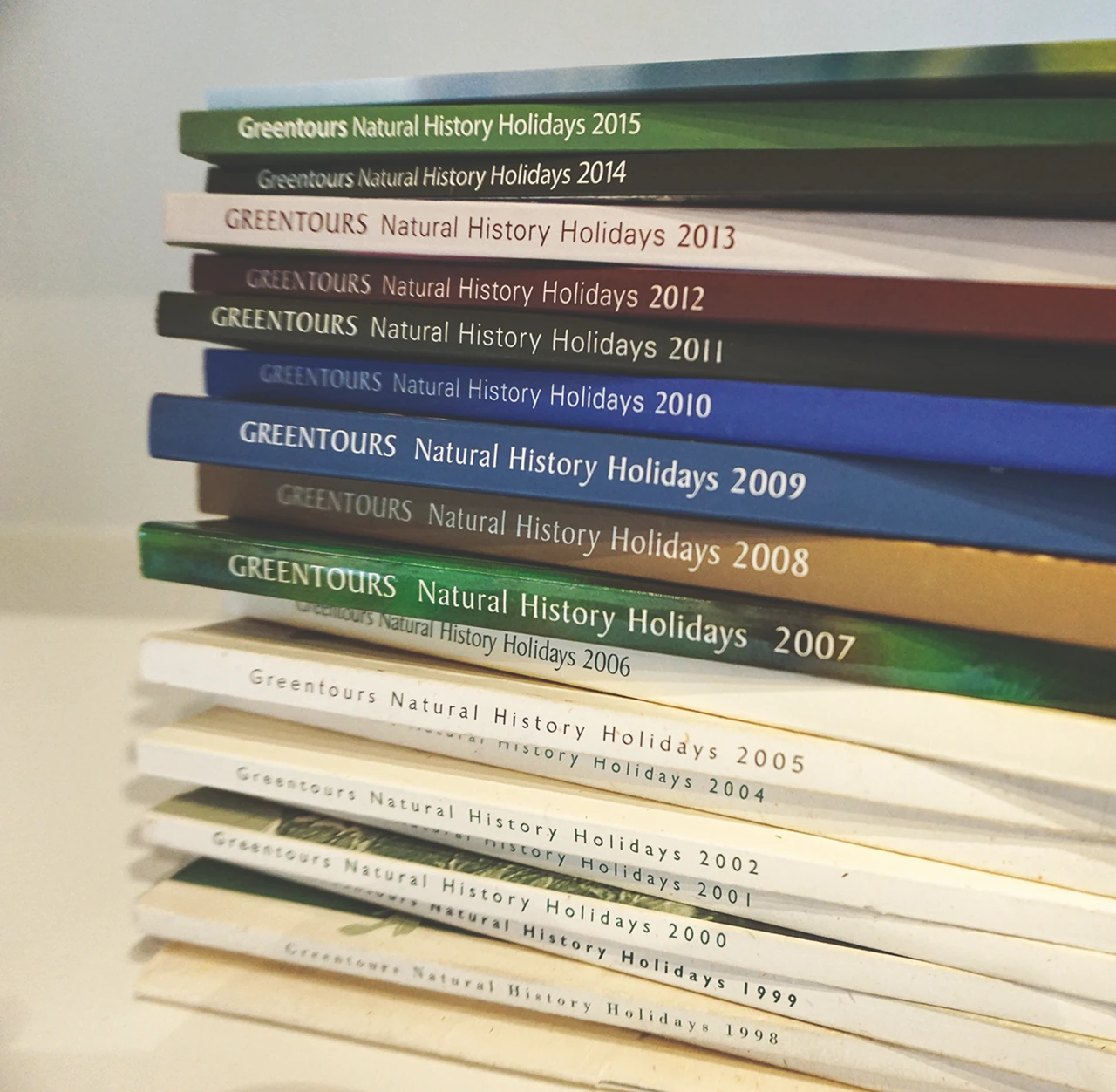Stack of past Greentours brochures
